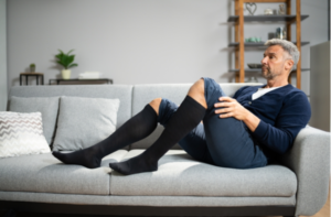 Man Wearing Medical Compression Stockings On Legs