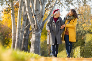 Granddaughter,Walking,With,Senior,Woman,In,Park,Wearing,Winter,Clothing.